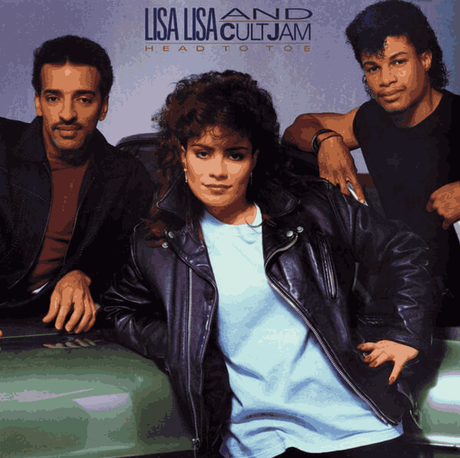 Album cover for “Head to Toe” by Lisa Lisa and Cult Jam, featuring three members posing in front of a car. Lisa Lisa stands center in a black leather jacket and light blue pants, flanked by two men in dark outfits. The background fades from blue to purple, with bold yellow text reading “LISA LISA AND CULT JAM – HEAD TO TOE” at the top. The image reflects 1980s fashion, attitude, and pop culture style.